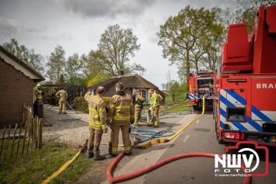Middelbrand voor brand in coniferen haag tussen twee woonboerderijen met rietenkap in Oosterwolde (gld). - © NWVFoto.nl