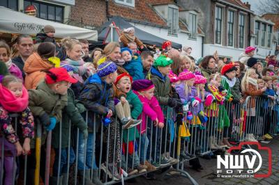 Kinderen genieten volop van de feestelijke aankomst van Sinterklaas op zijn stoomboot, gevolgd door een vrolijke stoet van Pietenboten in de haven van Elburg. - © NWVFoto.nl