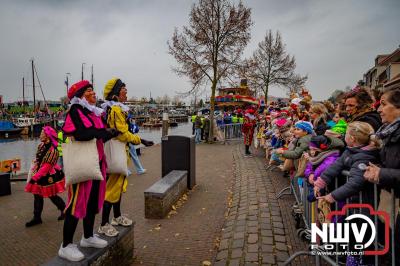 Kinderen genieten volop van de feestelijke aankomst van Sinterklaas op zijn stoomboot, gevolgd door een vrolijke stoet van Pietenboten in de haven van Elburg. - © NWVFoto.nl