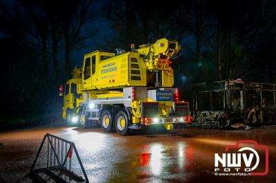 Berging van de 18 meter lange Walibi Express-bus, die maandag 23 december op de busparkeerplaats van Walibi in Biddinghuizen in brand vloog. - © NWVFoto.nl