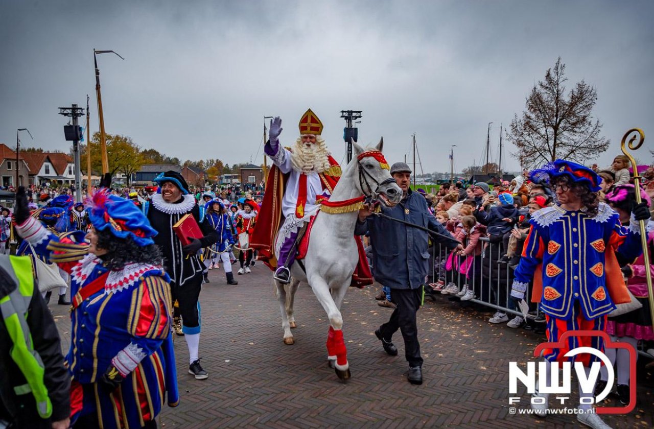 Kinderen genieten volop van de feestelijke aankomst van Sinterklaas op zijn stoomboot, gevolgd door een vrolijke stoet van Pietenboten in de haven van Elburg.