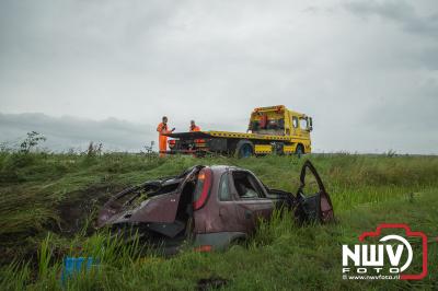 Bestuurder kan zelf uit auto komen nadat hij een aantal koprollen met zijn auto in de sloot had gemaakt. - © NWVFoto.nl
