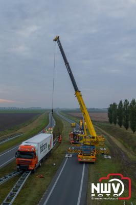 Berging van vrachtwagen op vangrails net voor het Elandweg viaduct over de Overijsselseweg N307 bij Dronten. - © NWVFoto.nl