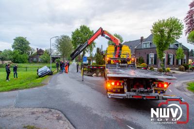 Berger moet auto weer op de weg zetten, nadat de bestuurster bij het achteruit rijden in een greppel belandde. - © NWVFoto.nl